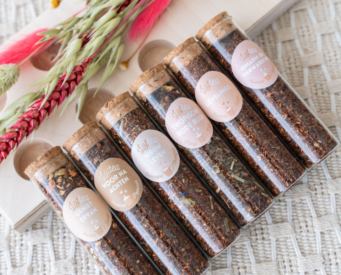 Een theeplankje met zes buisjes met verschillende smaken verse, Rooibos thee, te bestellen bij hettheeplankje.nl
