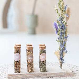 Een theeplankje met zes buisjes met verschillende smaken verse, kruiden thee, te bestellen bij hettheeplankje.nl