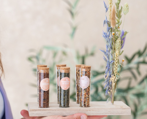 Lottea Theeplankje met verschillende buisjes met thee met een droogbloemetje ernaast.